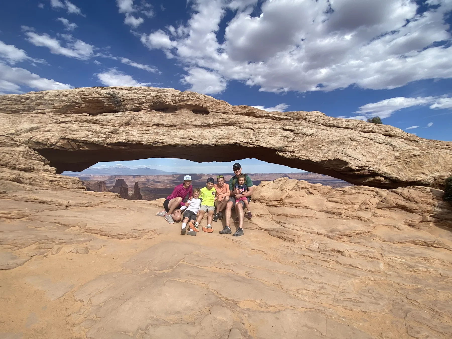 Family beneath a sandstone arch in Utah