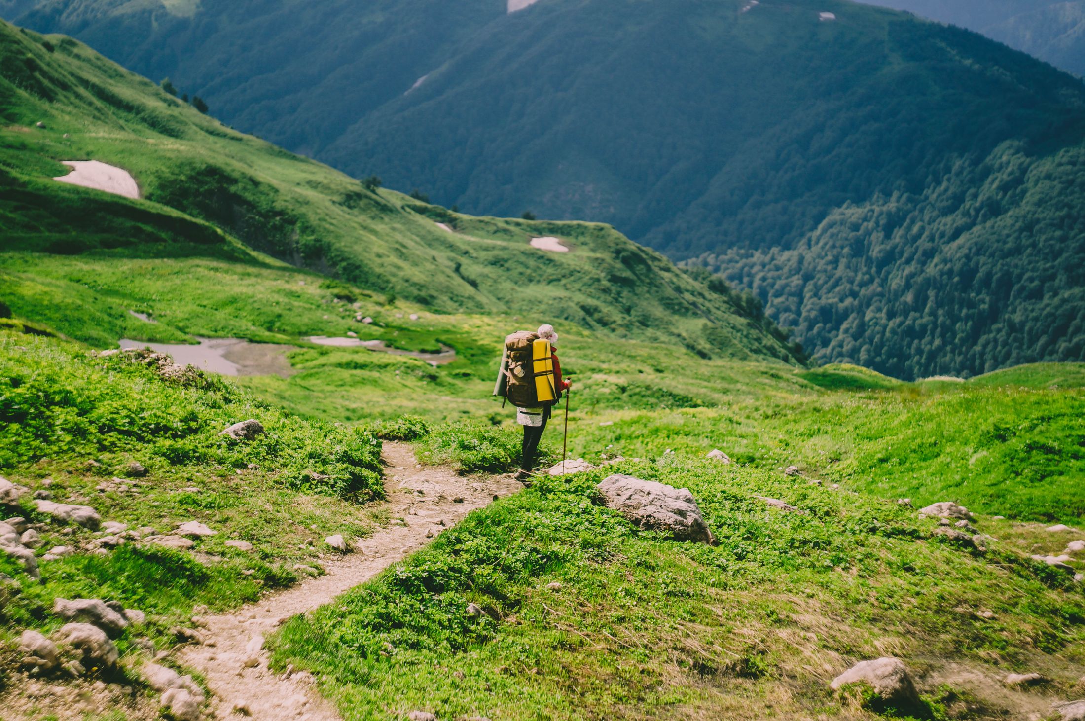 Hiker making progress along an alpine mountain trail