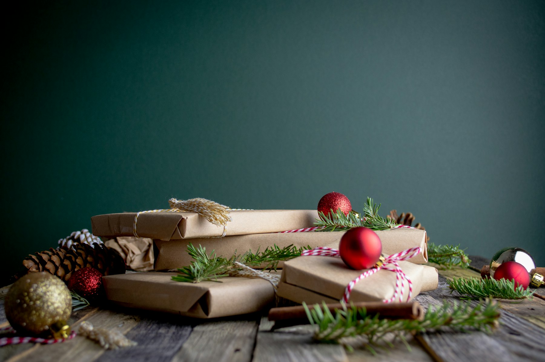 In Packpapier verpackte Geschenke mit roten Weihnachtskugeln