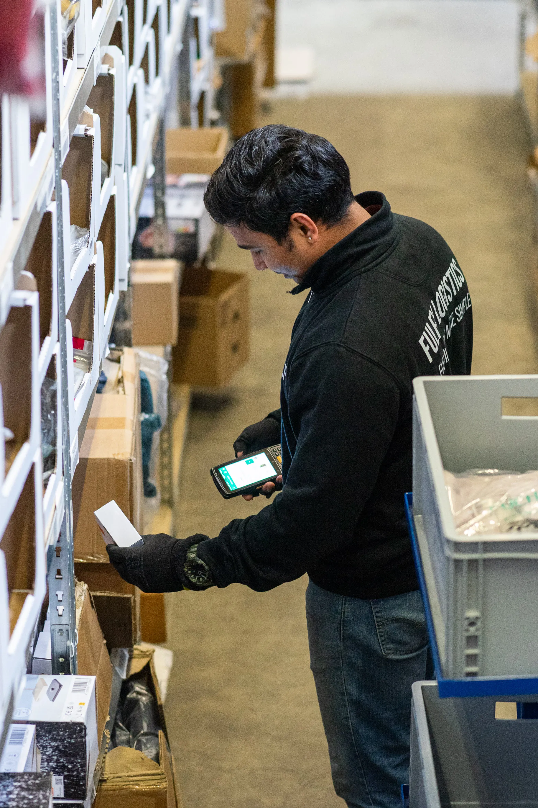 FulFy-Mitarbeiter kommissioniert einen Artikel mit dem Handscanner