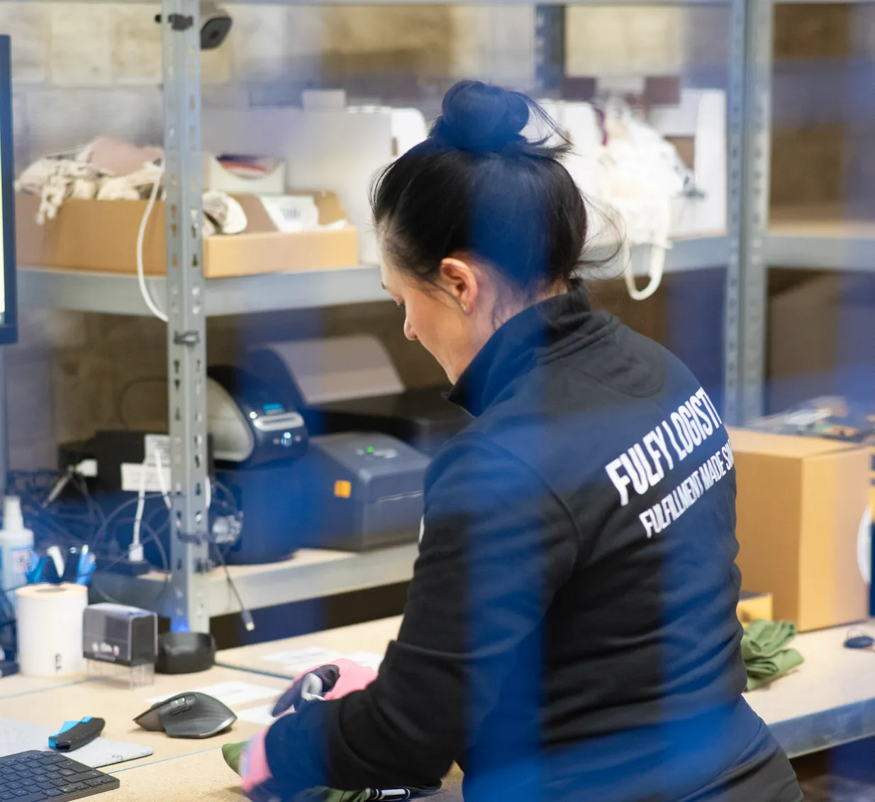 FulFy-Mitarbeiterin bereitet am Packplatz einen zurückgesendeten Artikel auf