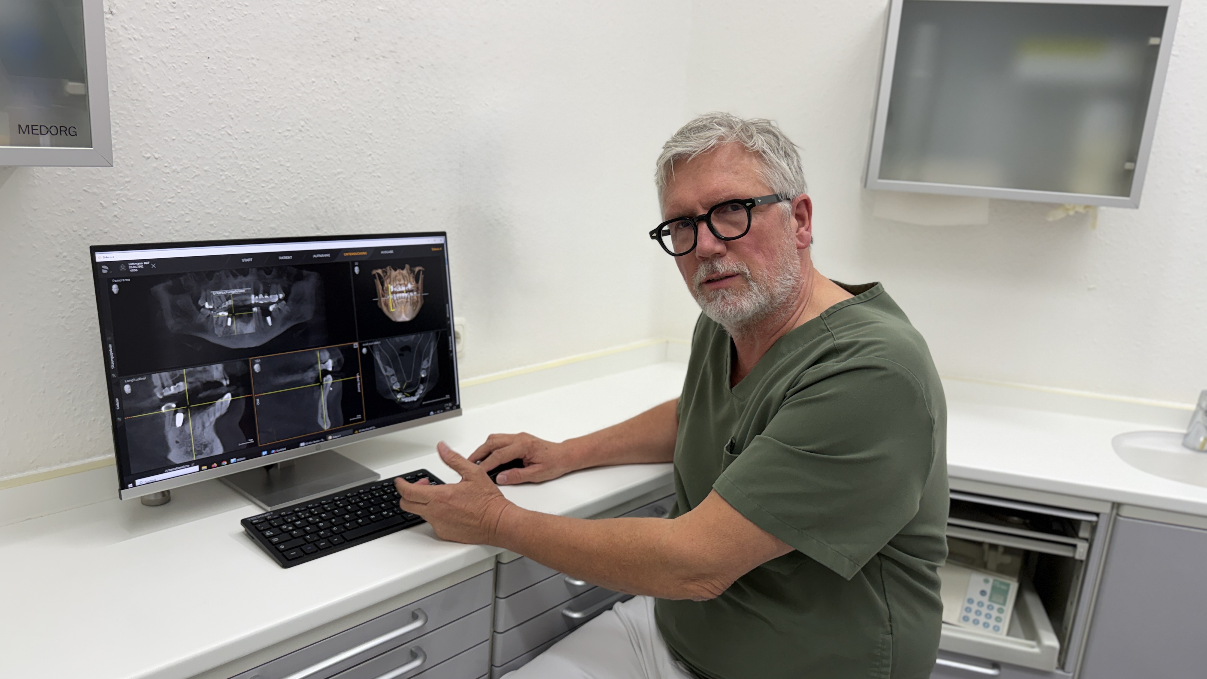 Dr. Ralf Lüttmann am Bildschirm mit dem 3D-Röntgenbild der Kiefer (DVT)