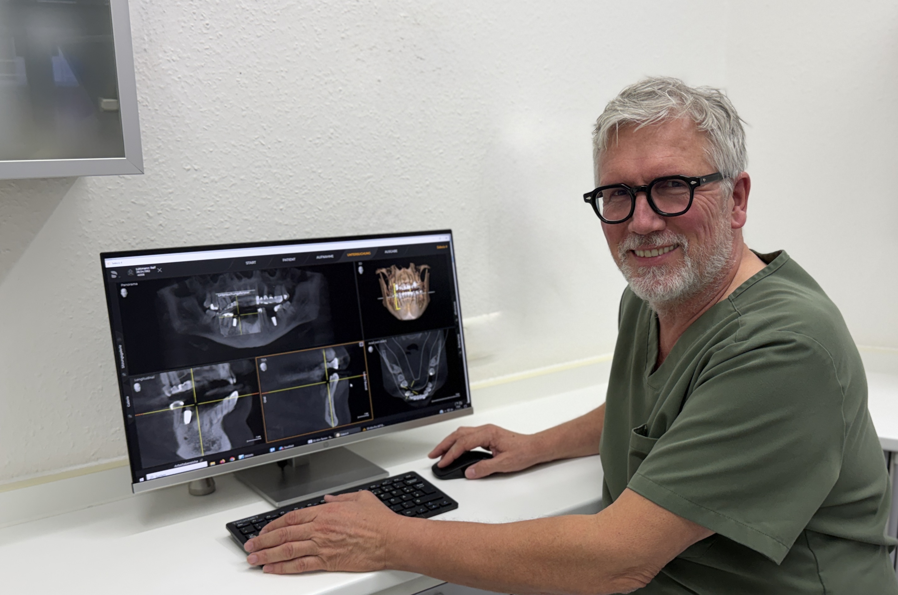 Dr. Ralf Lüttmann am Bildschirm mit dem 3D-Röntgenbild der Kiefer (DVT)