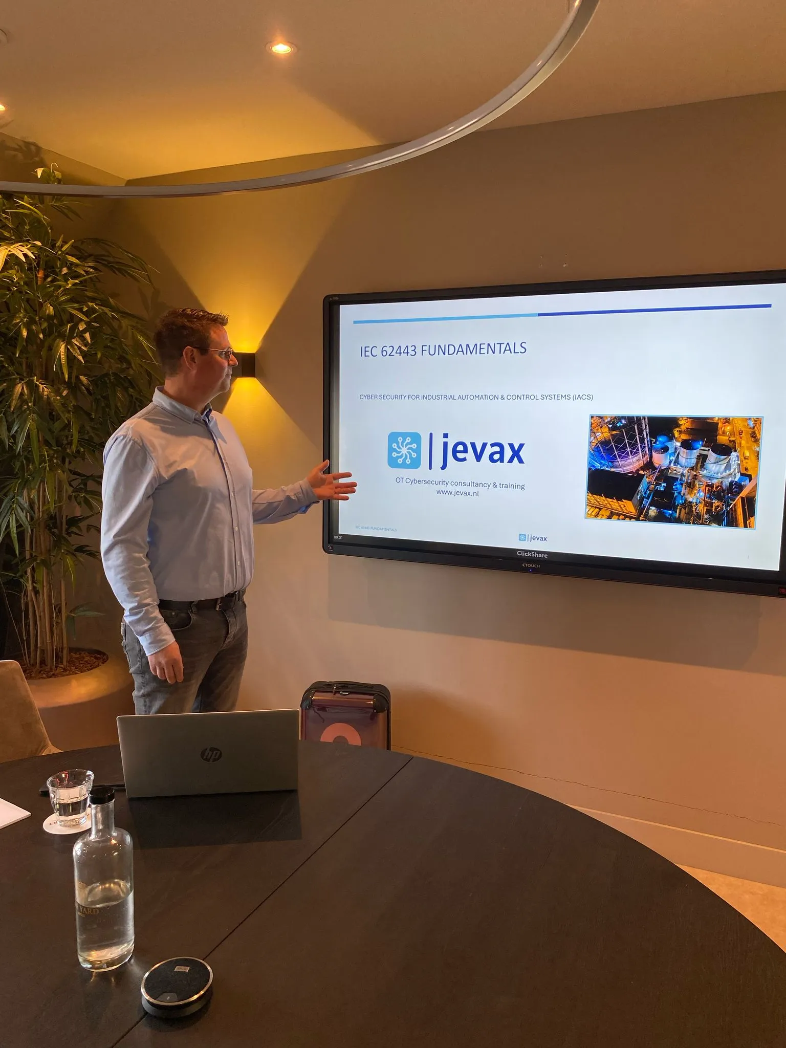 Jevax-trainer licht een presentatie over IEC 62443 toe.