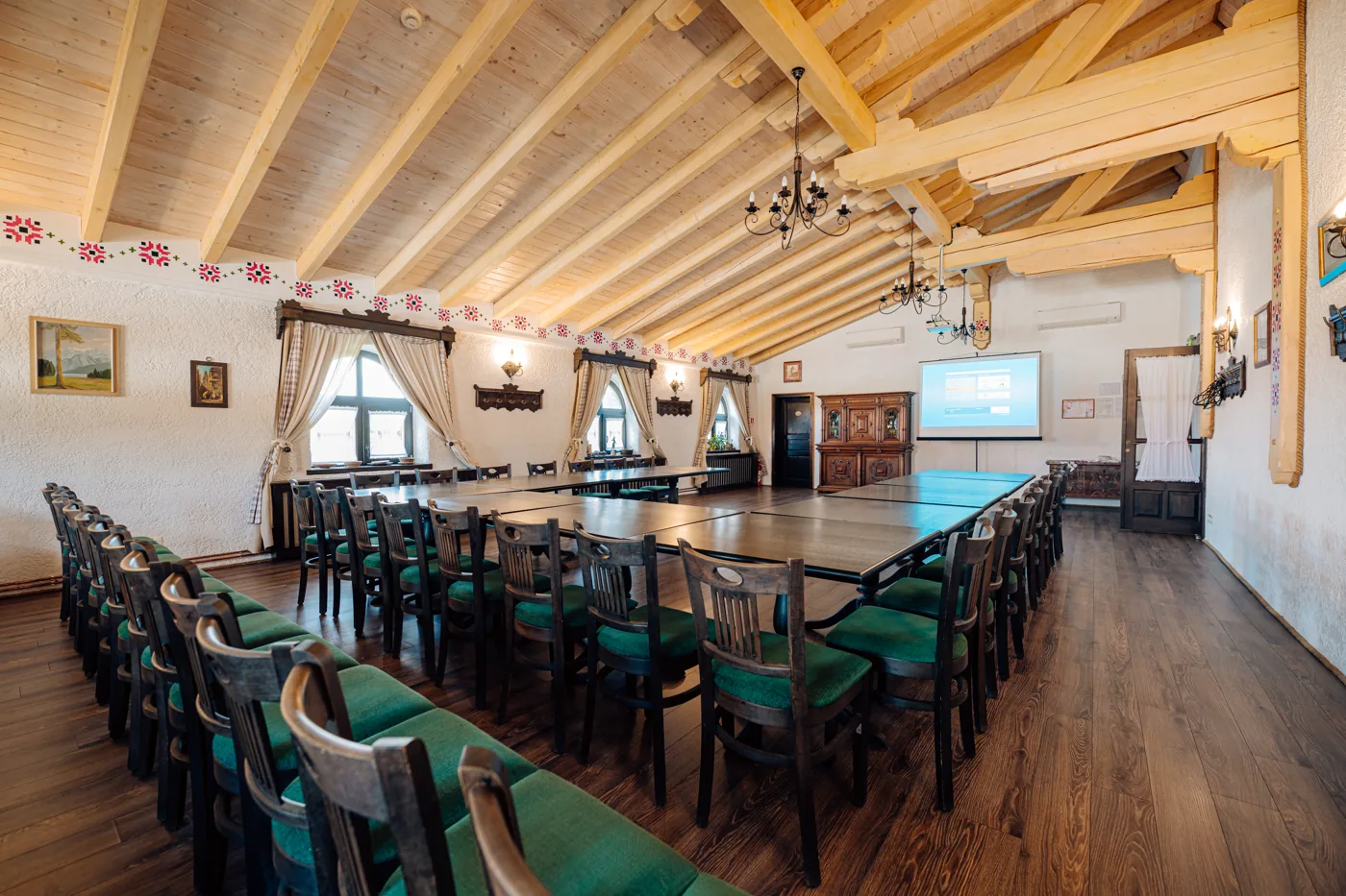 Sala de conferințe a Conacului Maria Theresa, cu mese în U și ecran de proiecție