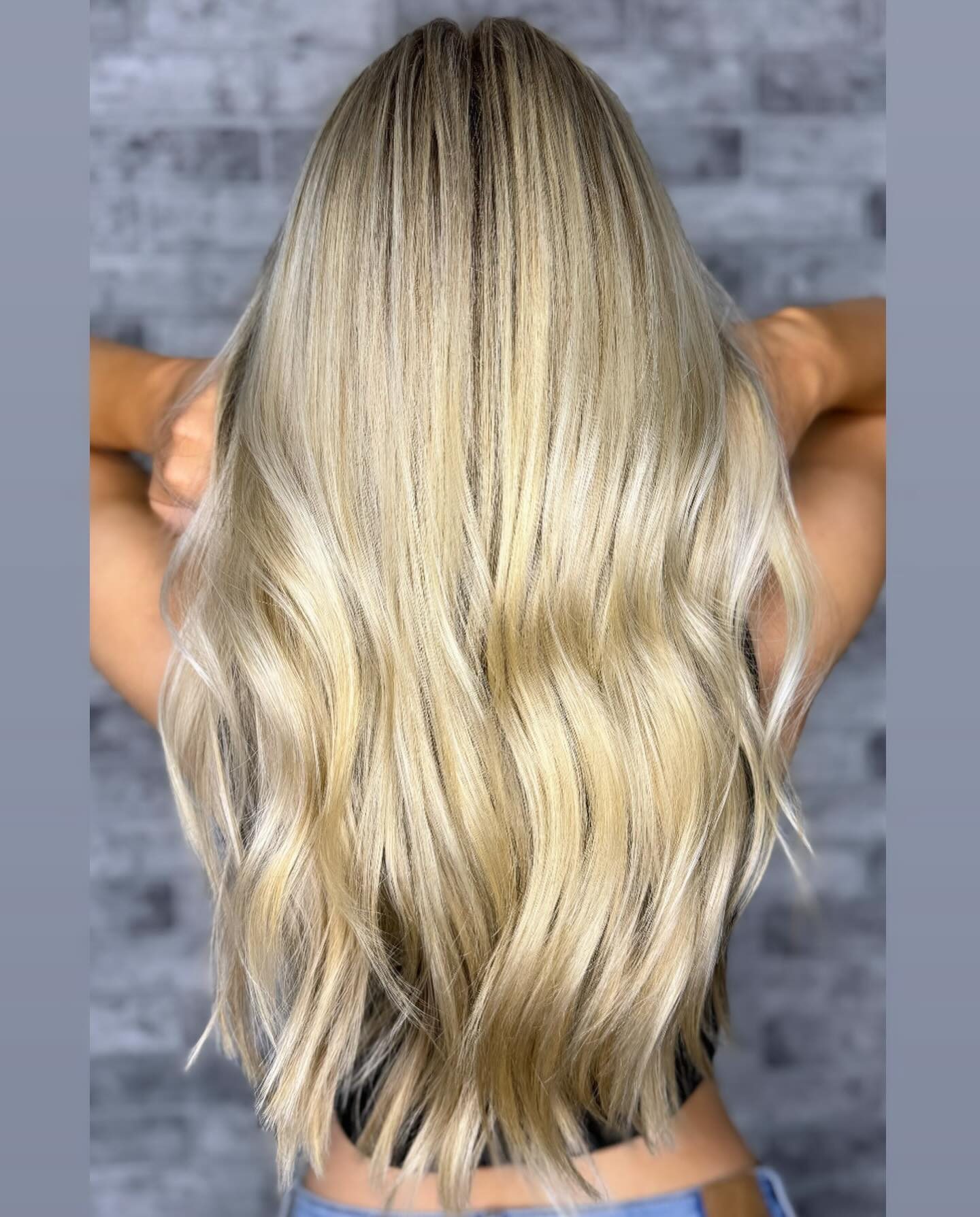 Ash blonde balayage with soft waves, back view