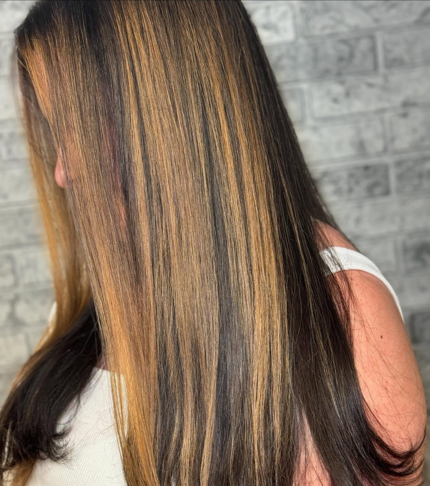 Dark hair with bright caramel face-framing highlights