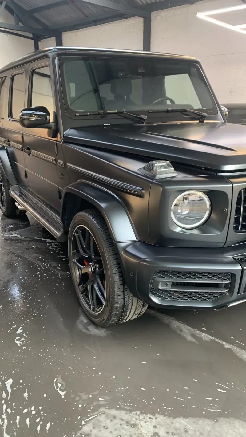 Zwarte matte SUV op een natte atelier-vloer