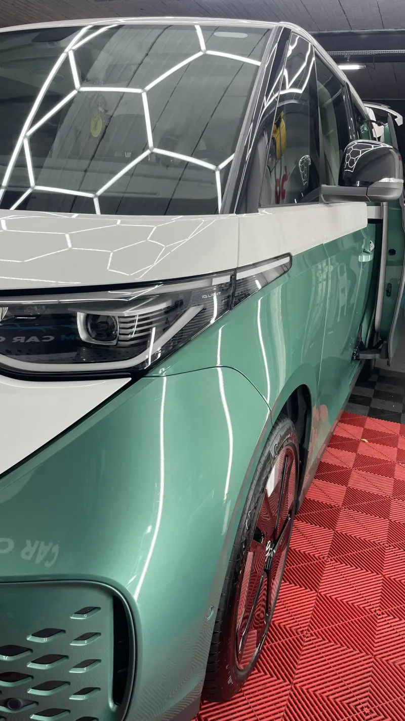 Groen-witte wagen met spiegelende lichtreflecties in de lak