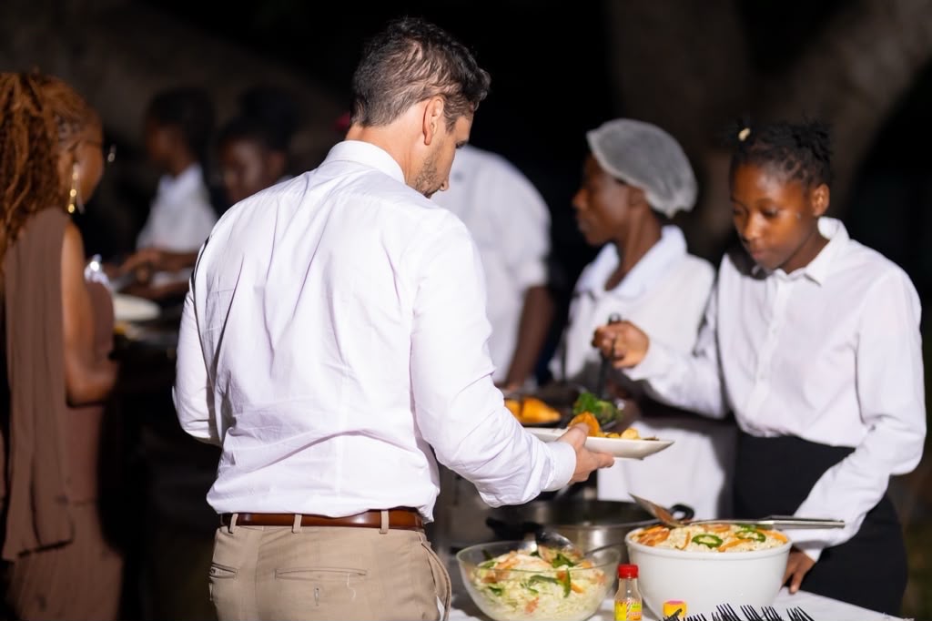 Guests served at an evening buffet by catering staff