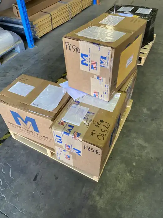 Boxed Mercer valves stacked on a pallet, labelled for dispatch