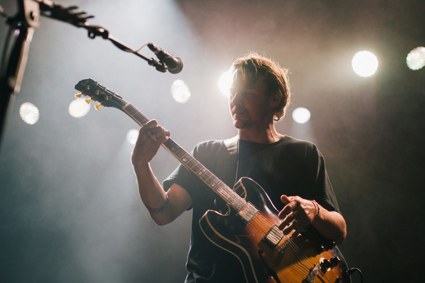 Musician performing on stage under a spotlight