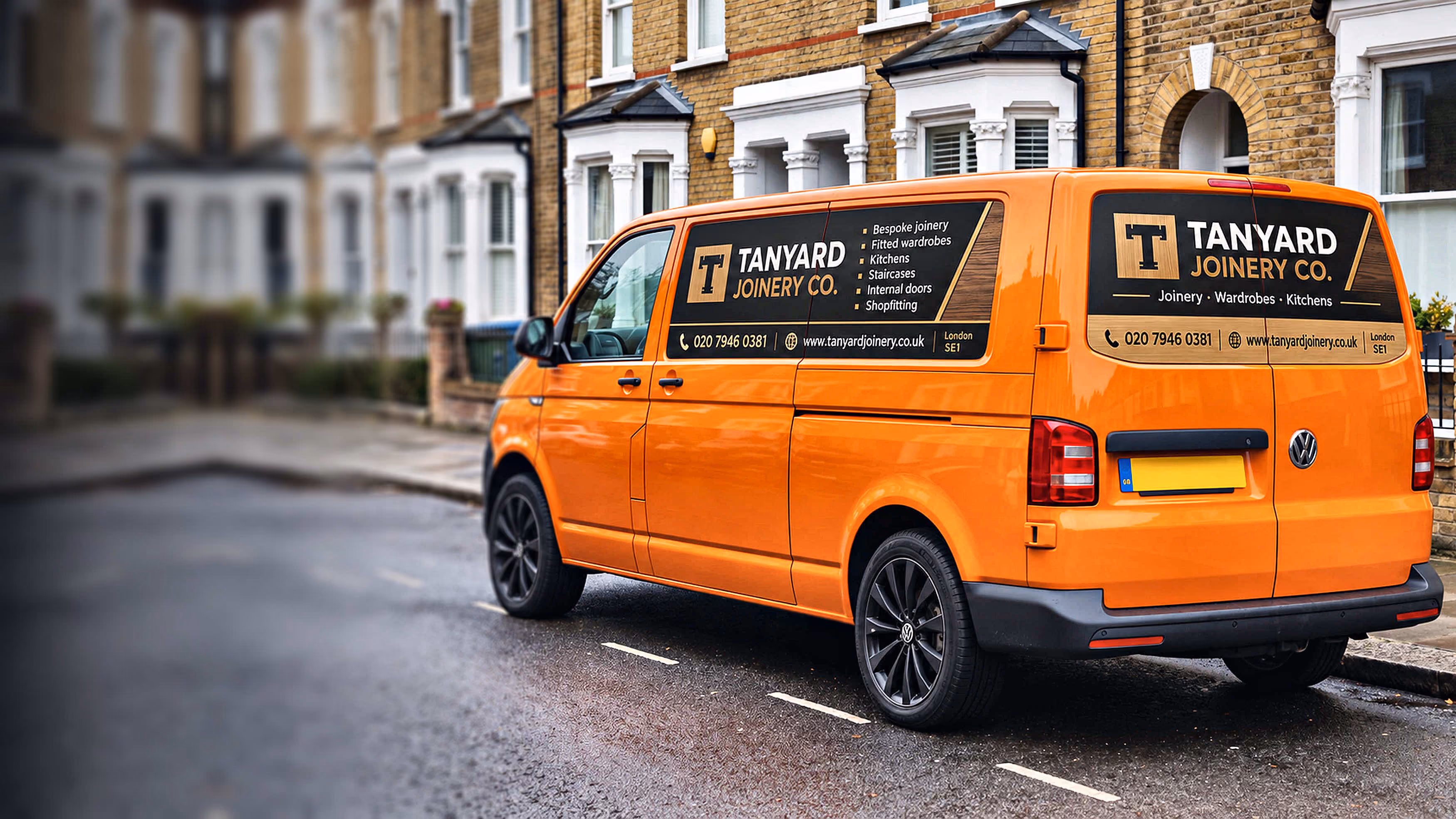 Silver Ford Transit Custom with maroon and gold magnetic van signs for a decorating company, parked on a cobbled Edinburgh street