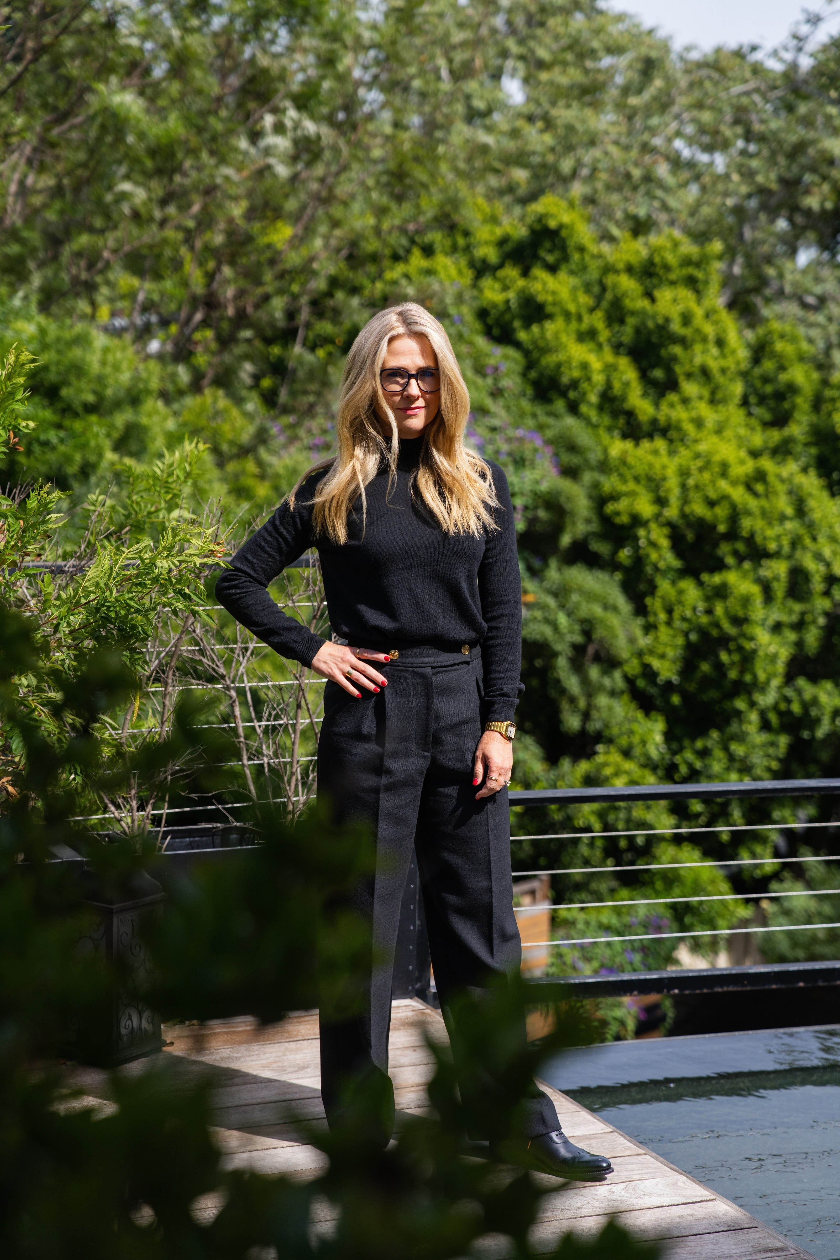 Breanne Wahl, Northeast Los Angeles real estate agent with ACME | SERHANT., standing on a hillside deck among the trees on Mt. Washington, Los Angeles