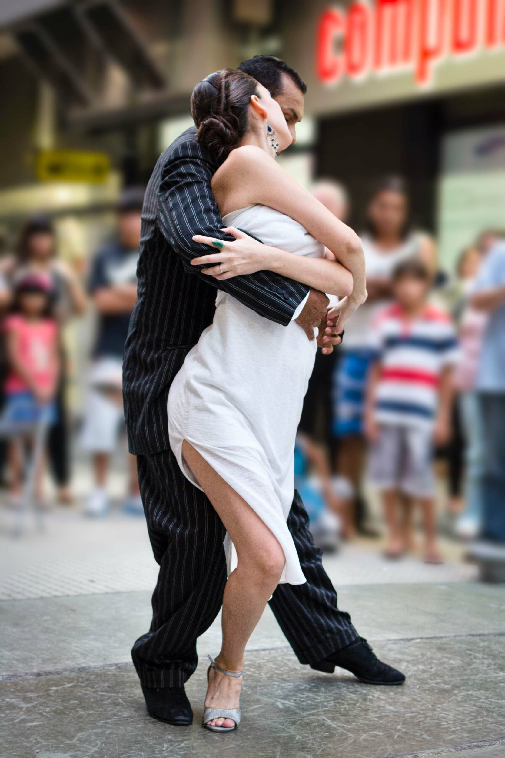 Pareja bailando tango en una calle peatonal frente a espectadores en Buenos Aires