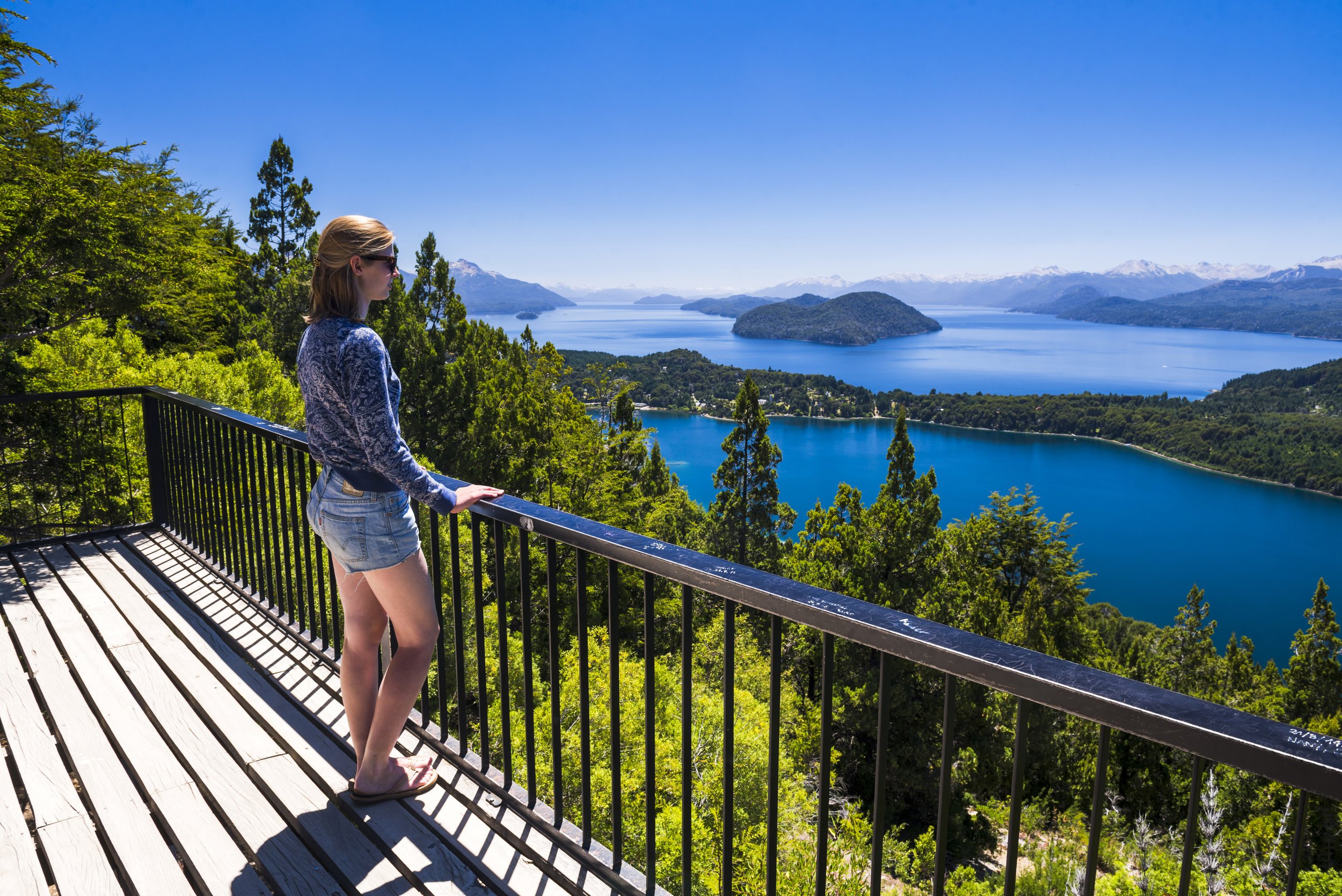 Una mujer observa la vista panorámica de lagos y montañas desde el mirador del Cerro Campanario.
