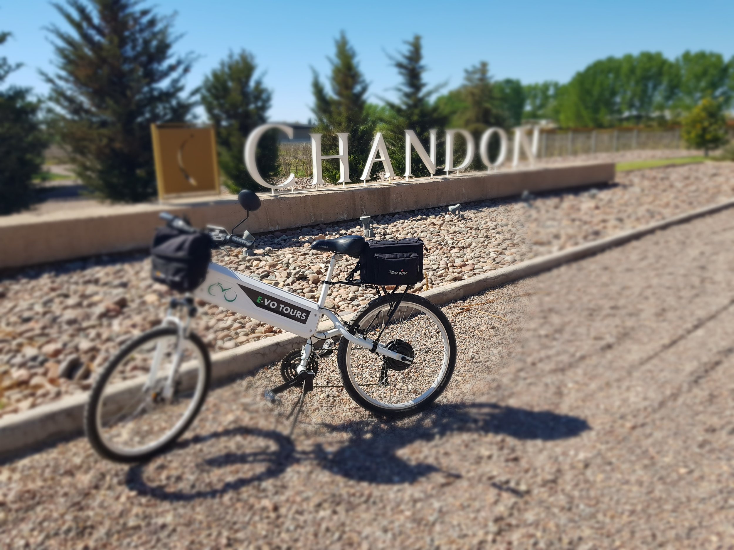 Bicicleta eléctrica estacionada frente al cartel de la bodega Chandon en una zona vitivinícola.