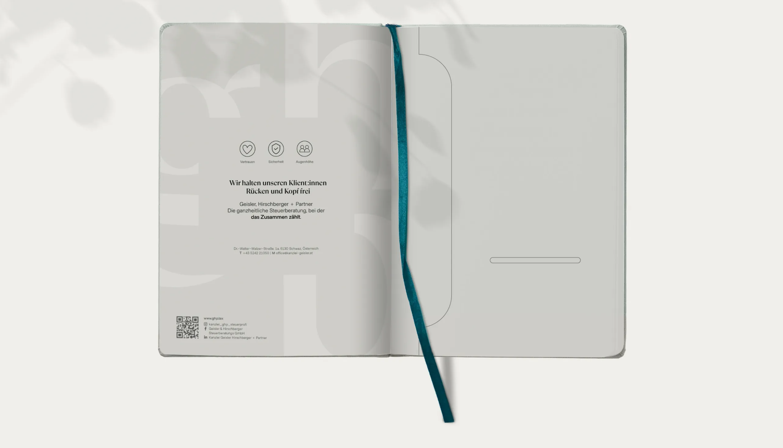 Aufgeschlagenes GHP-Notizbuch mit Werte-Icons und dem Satz „Wir halten unseren Klient:innen Rücken und Kopf frei“
