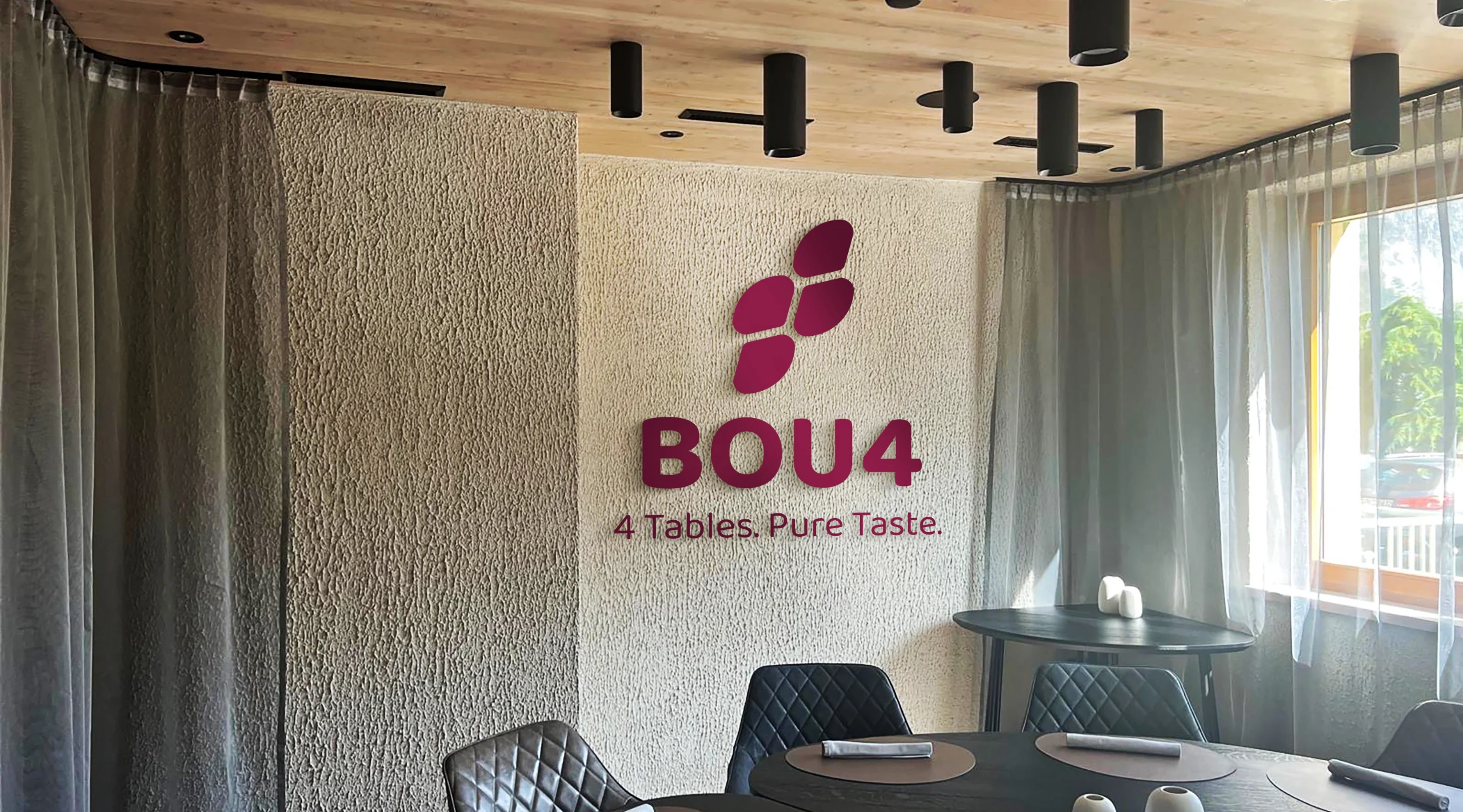 BOU4 Restaurantraum mit Logo und Claim „4 Tables. Pure Taste.“ an der Wand