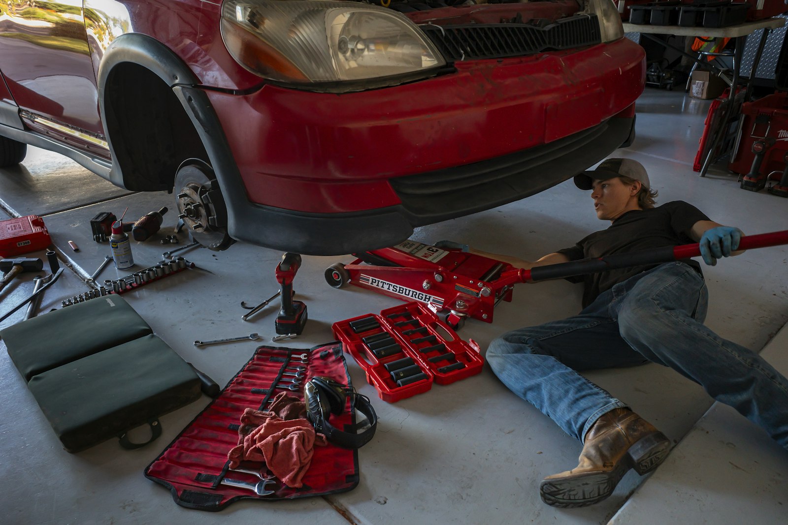 A mechanic working under a car in a garage