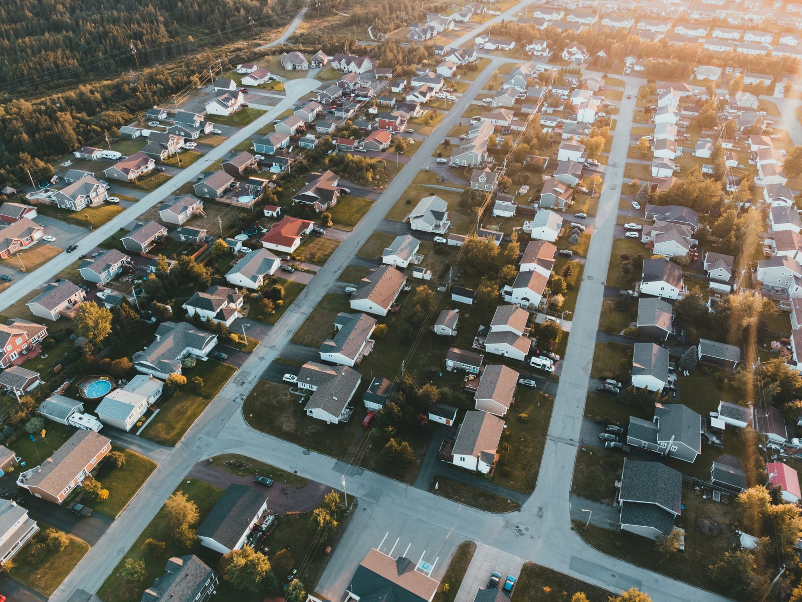 Aerial view of a suburban neighbourhood of houses and streets at sunset