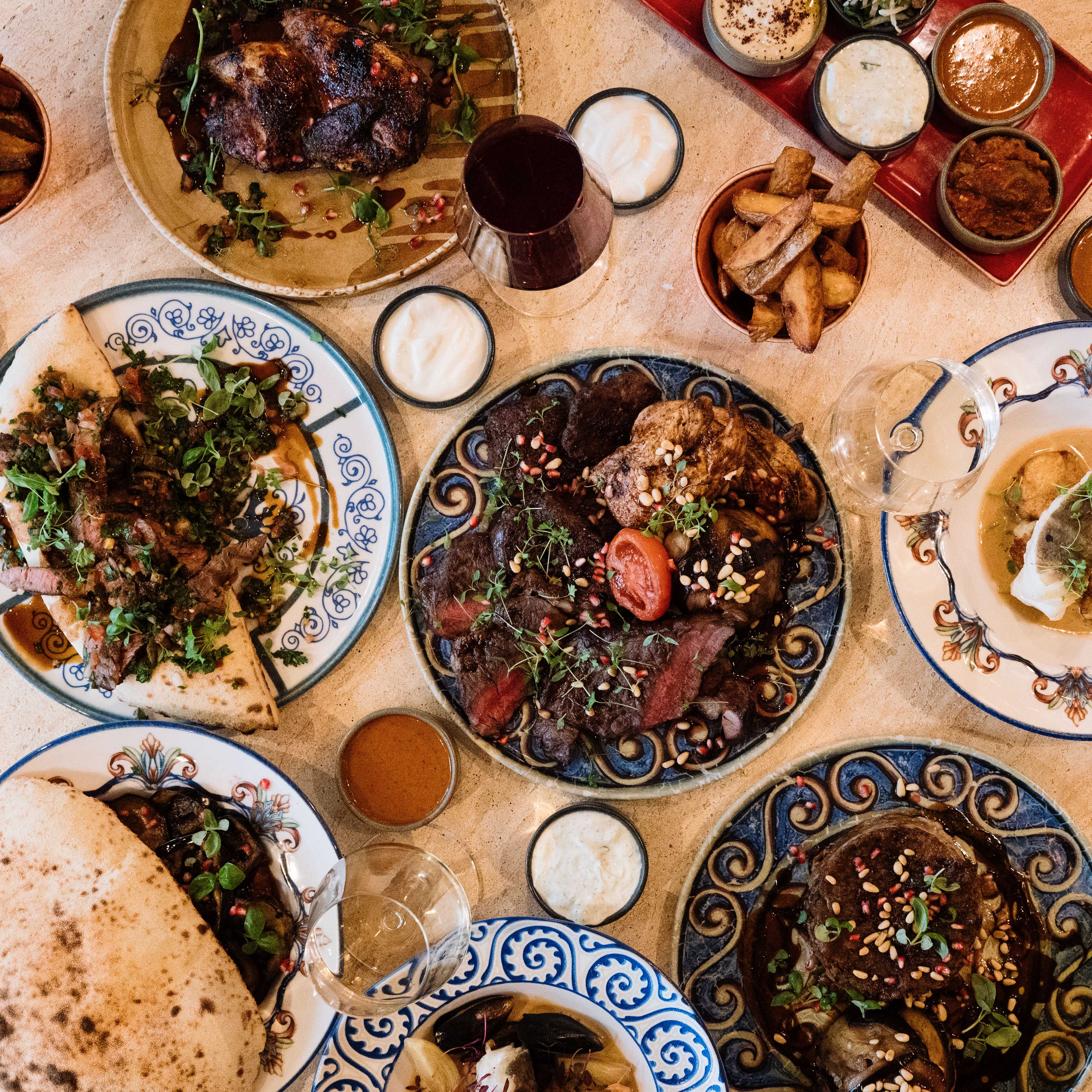 A table spread with sharing dishes, flatbreads and dips at Bazaar