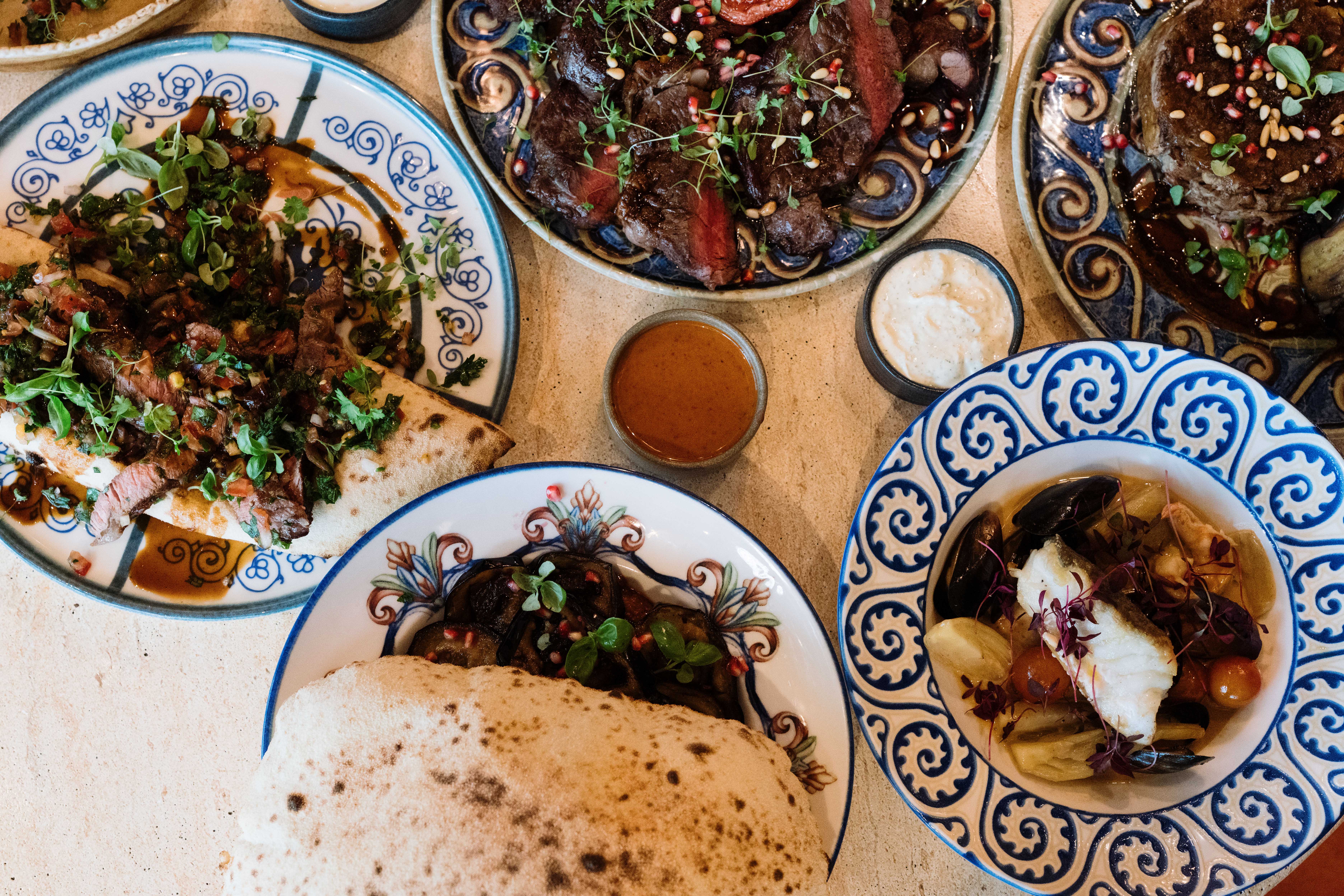 Sharing dishes, flatbreads, sauces and seafood laid out at Bazaar