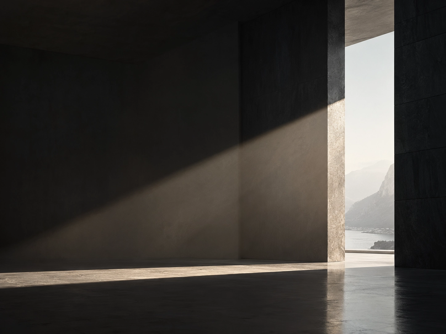 Sunlight casts a diagonal beam across a dark, empty concrete interior room with a large, open doorway revealing a distant view of misty mountains and a body of water.