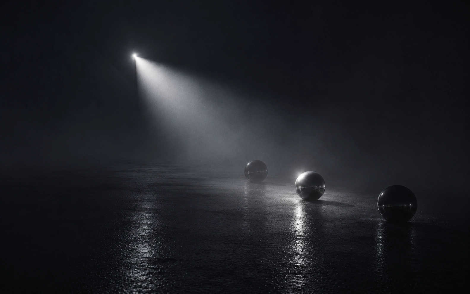 Dark scene with three shiny metallic spheres on a wet reflective surface, illuminated by a strong focused beam of light from the upper left corner.