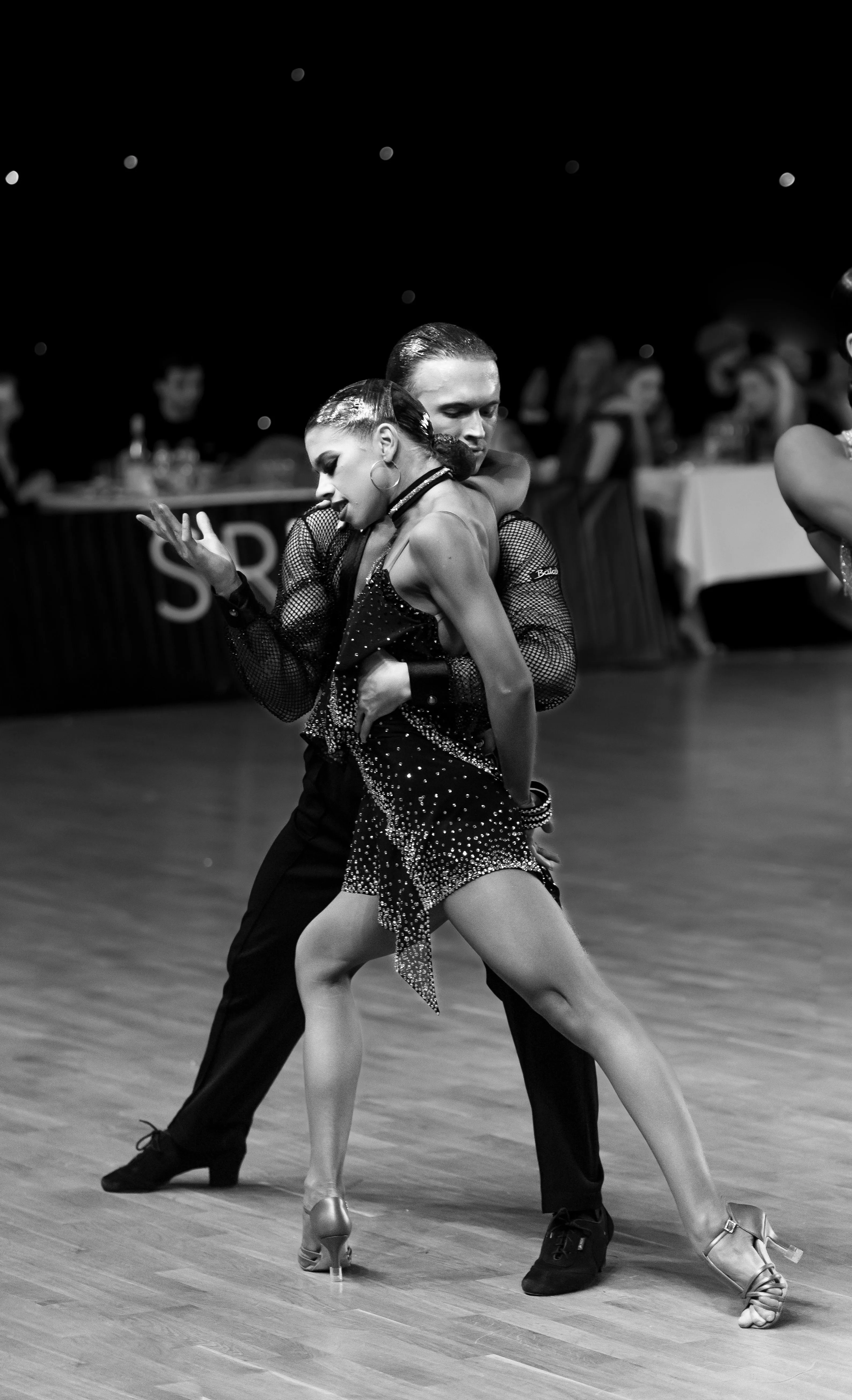 A Latin dance partnership in an expressive full-body pose.