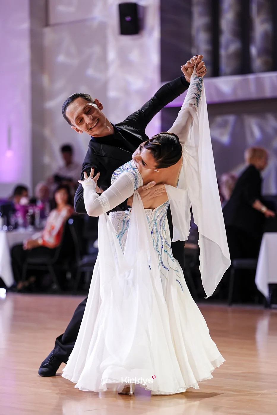 A ballroom partnership in a white gown performing at the 2025 Jurmala Dance Festival.