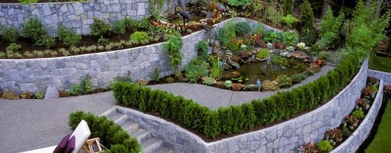 Terraced garden retaining walls with tiered planting beds in a residential backyard
