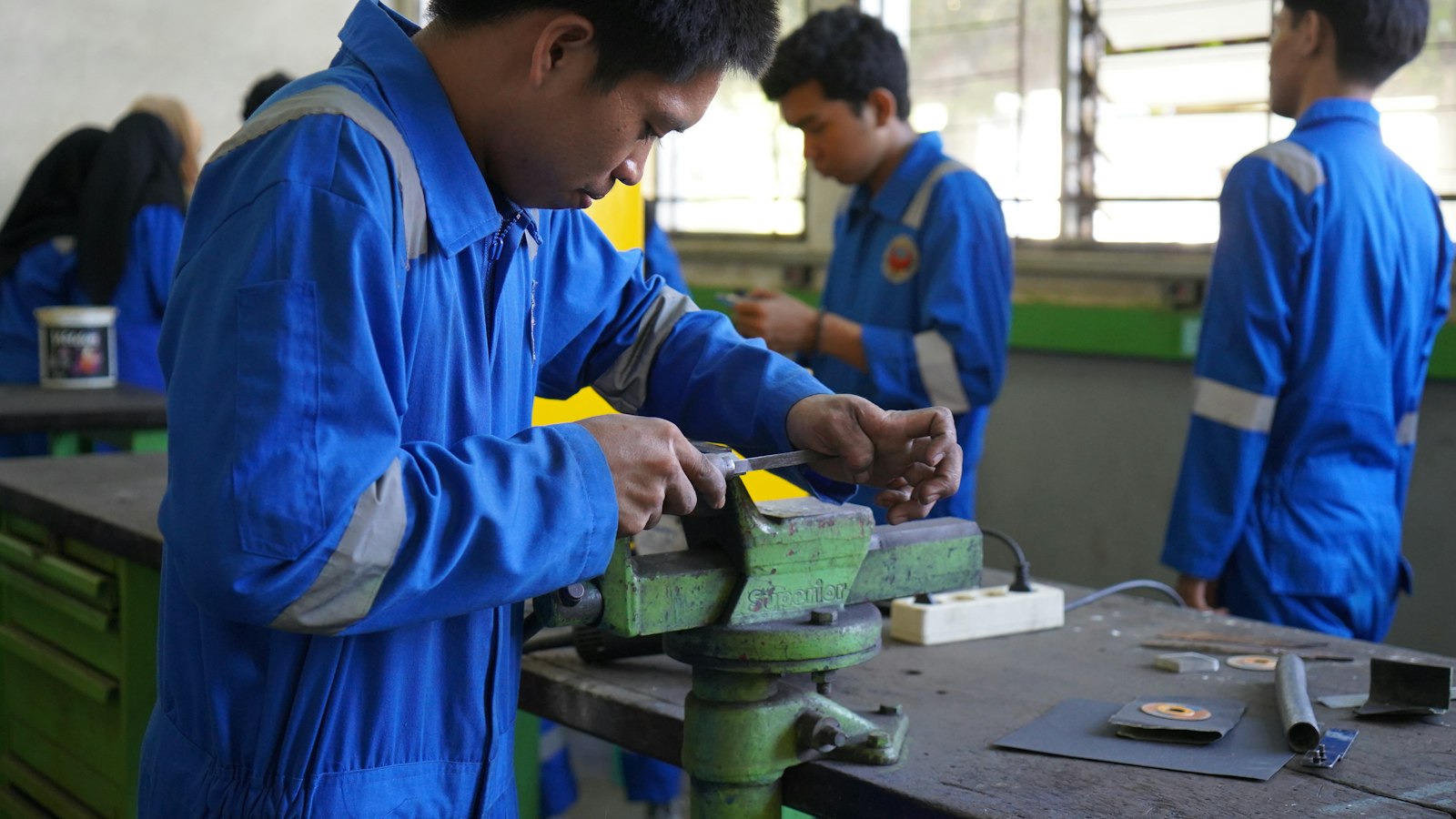 Trainees working at a bench in a practical training workshop