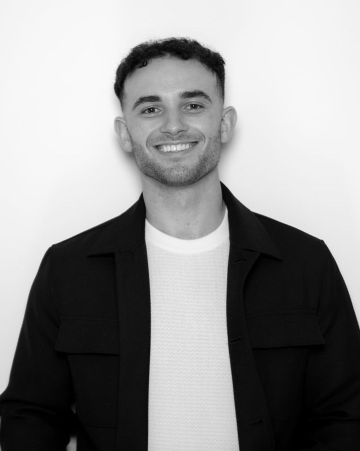 Sam Beres in a black jacket against a white wall