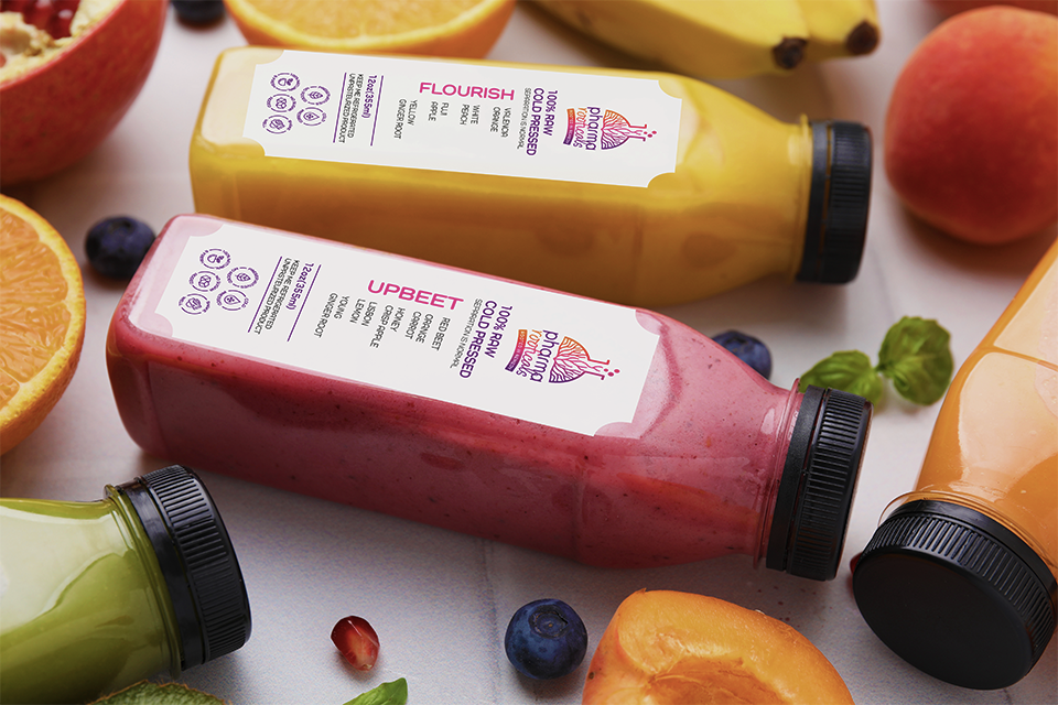 Pharmarooticals cold-pressed juice bottles surrounded by fresh fruit