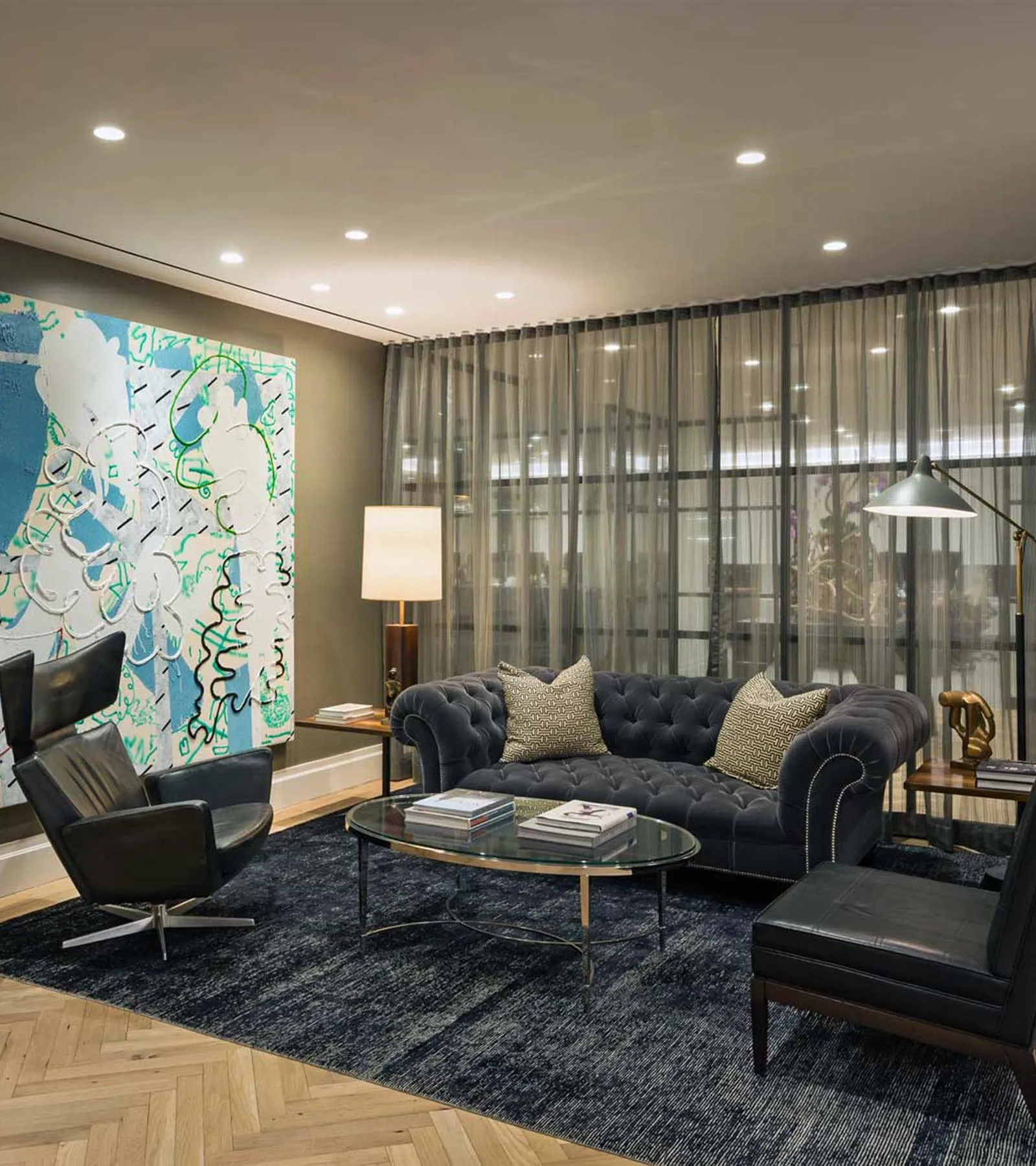 The Commons Capital reception area, with a sofa, armchairs, a coffee table and a large painting.