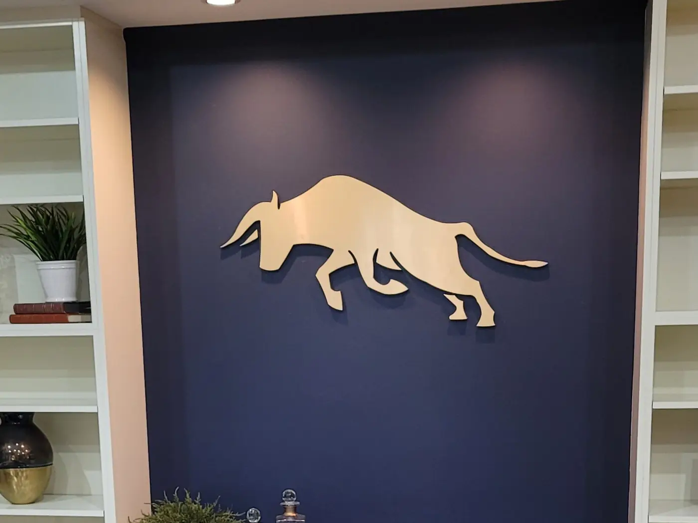 Cut metal 3D logo sign on a navy office wall