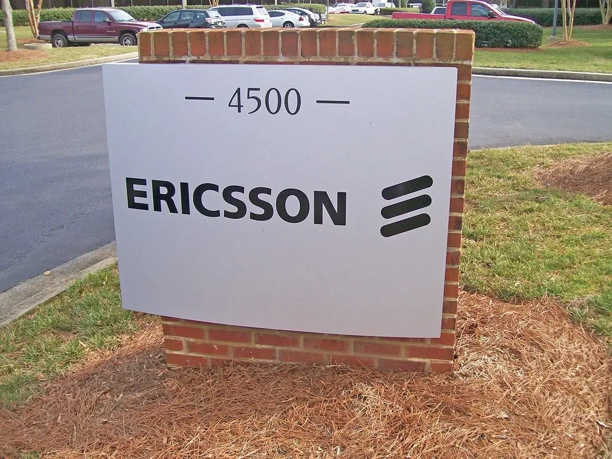 Aluminum address and logo sign for Ericsson in a brick base