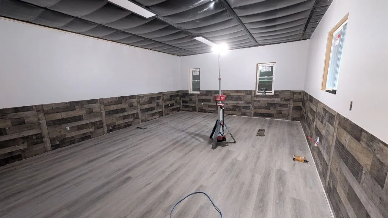 Finished room with wood-look wainscot and plank flooring