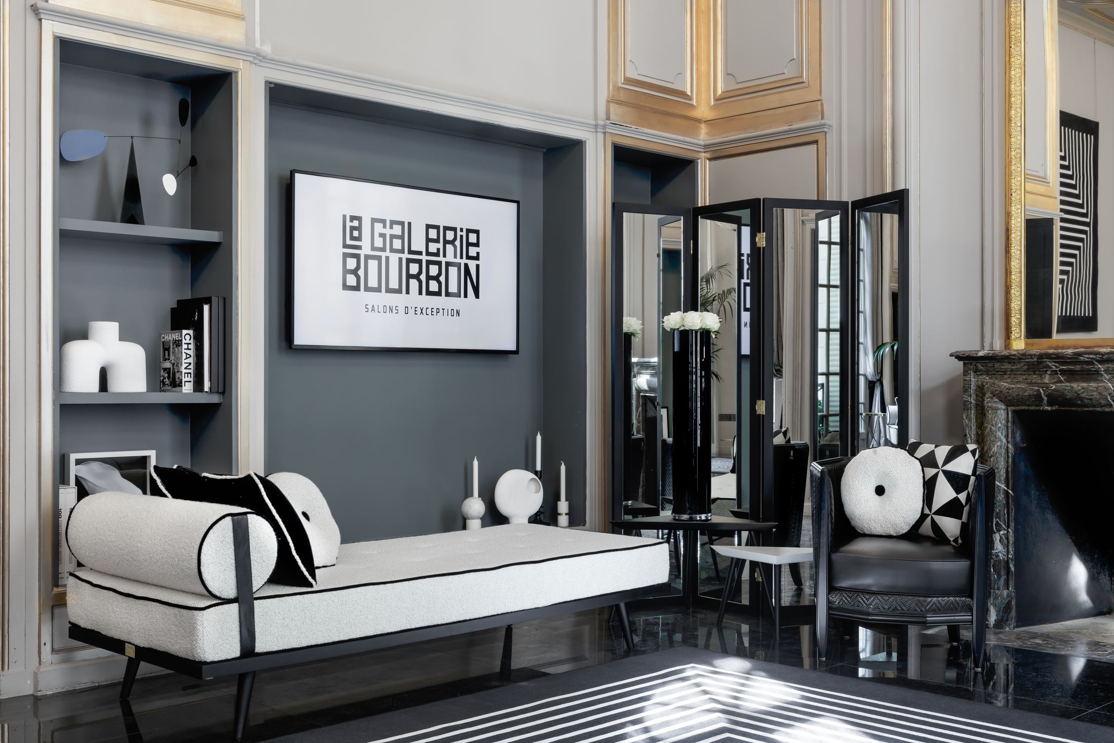 Salon de la Galerie Bourbon avec le logo du lieu, mobilier noir et blanc