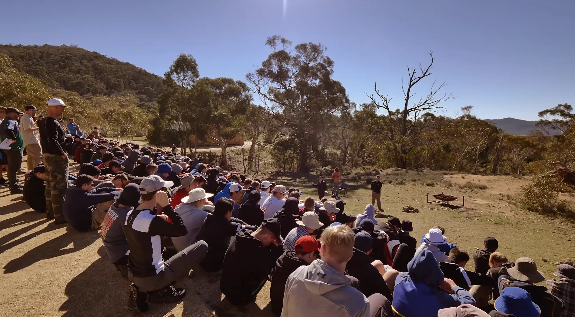Expeditioners seated together in a large circle gathering in the high country