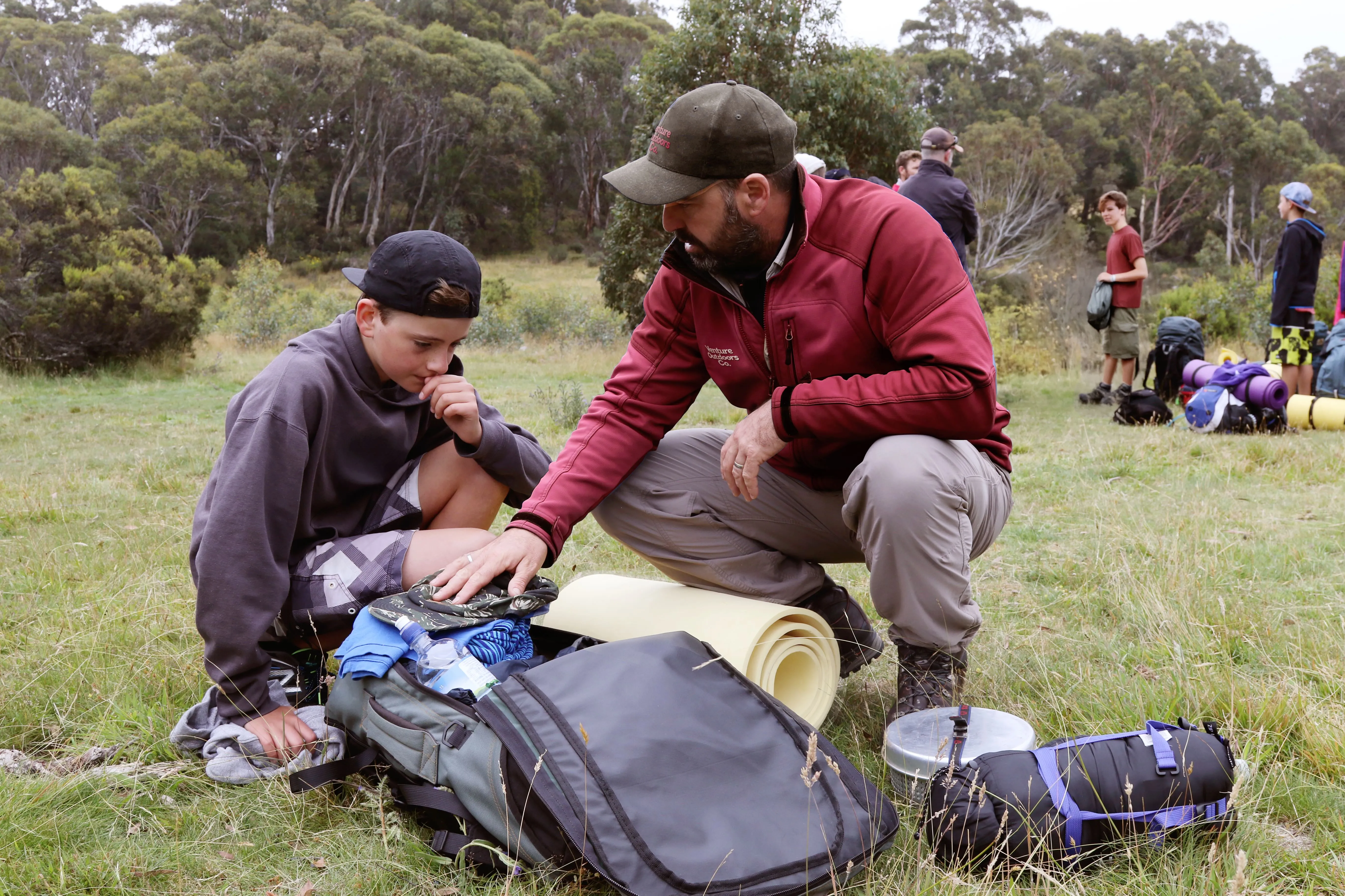A Venture Outdoors guide helping an expeditioner check their pack