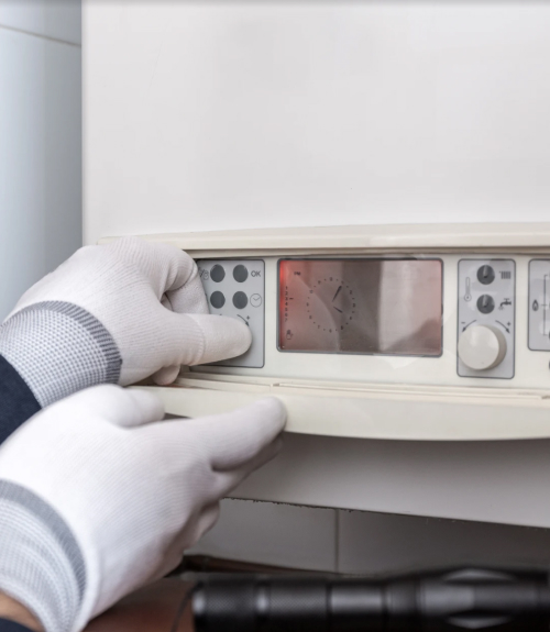 Heating engineer adjusting a boiler