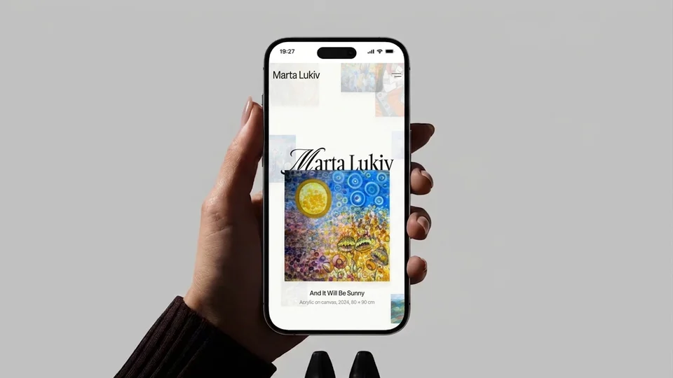 Marta Lukiv mobile site on a phone held up against a grey wall