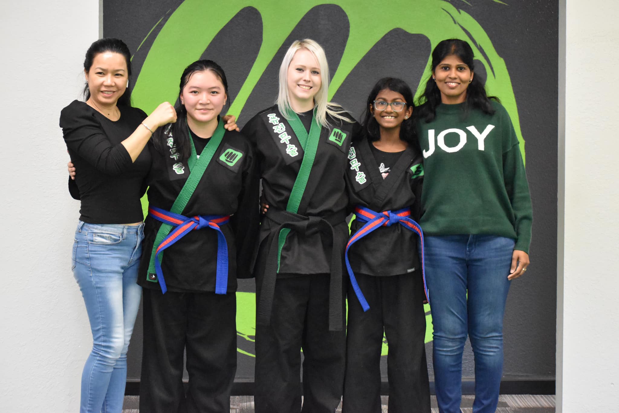 Kids with their families after earning new belts at Fusion Martial Arts