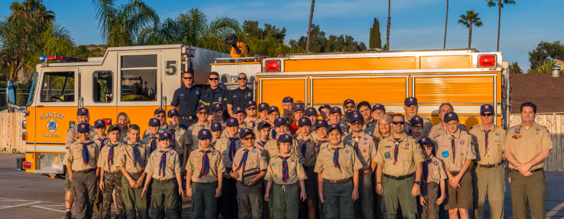 Santee firefighters posing with a large group of Scouts in front of fire engines