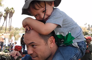Firefighter carrying a child on his shoulders at a community event