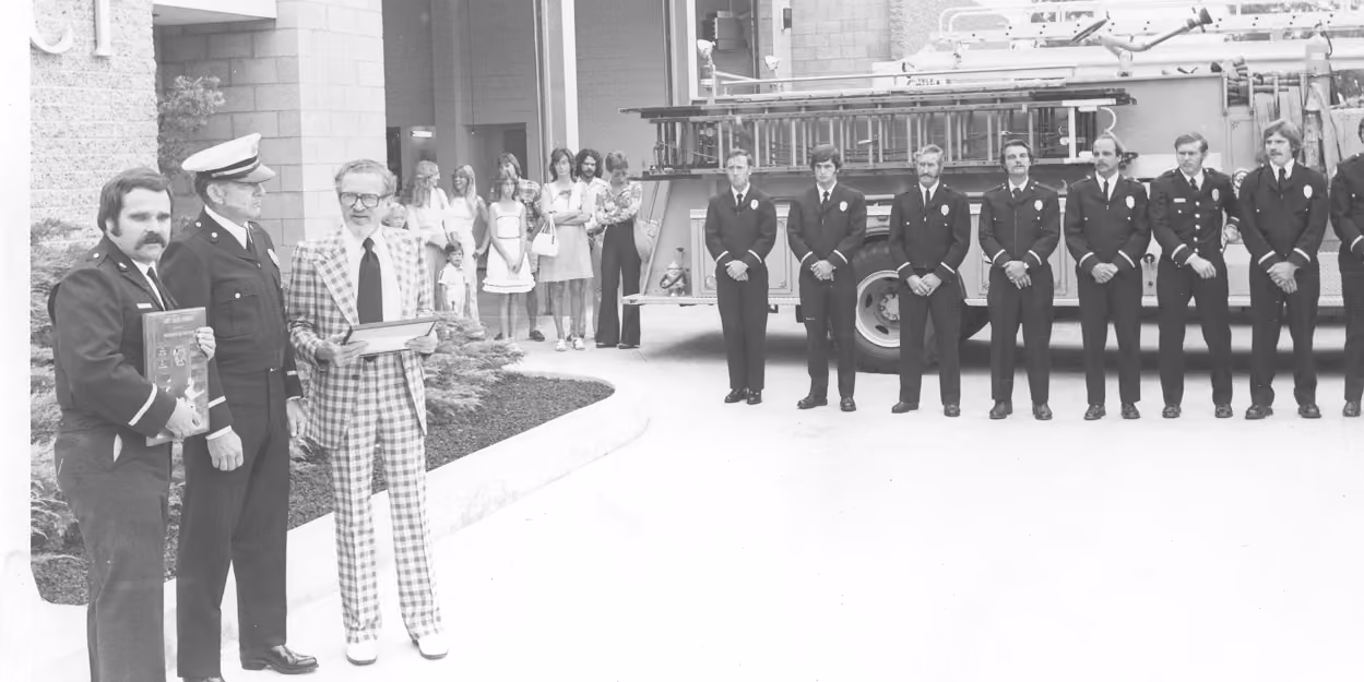 Black-and-white photo of the Santee fire station opening ceremony with firefighters lined up beside a fire engine