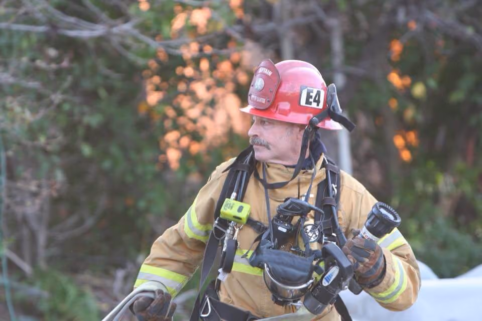 Rick Williams in turnout gear and helmet working at a fire scene