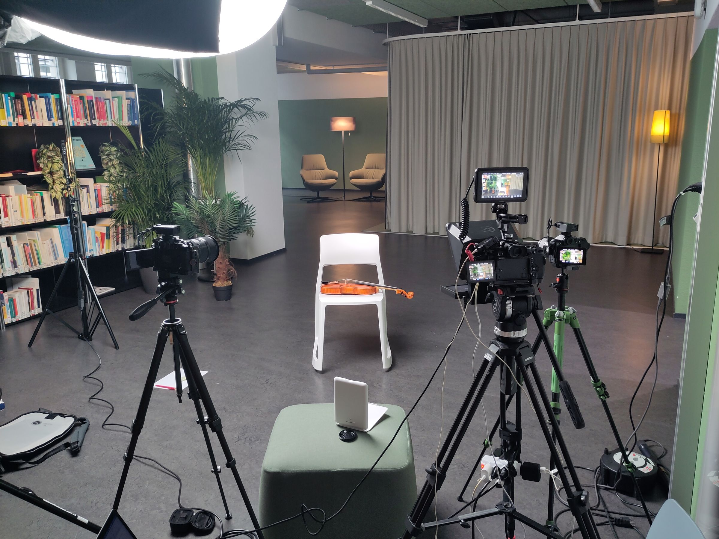 Interview-Set mit Stuhl, Kameras und Leuchte in einer Bibliothek